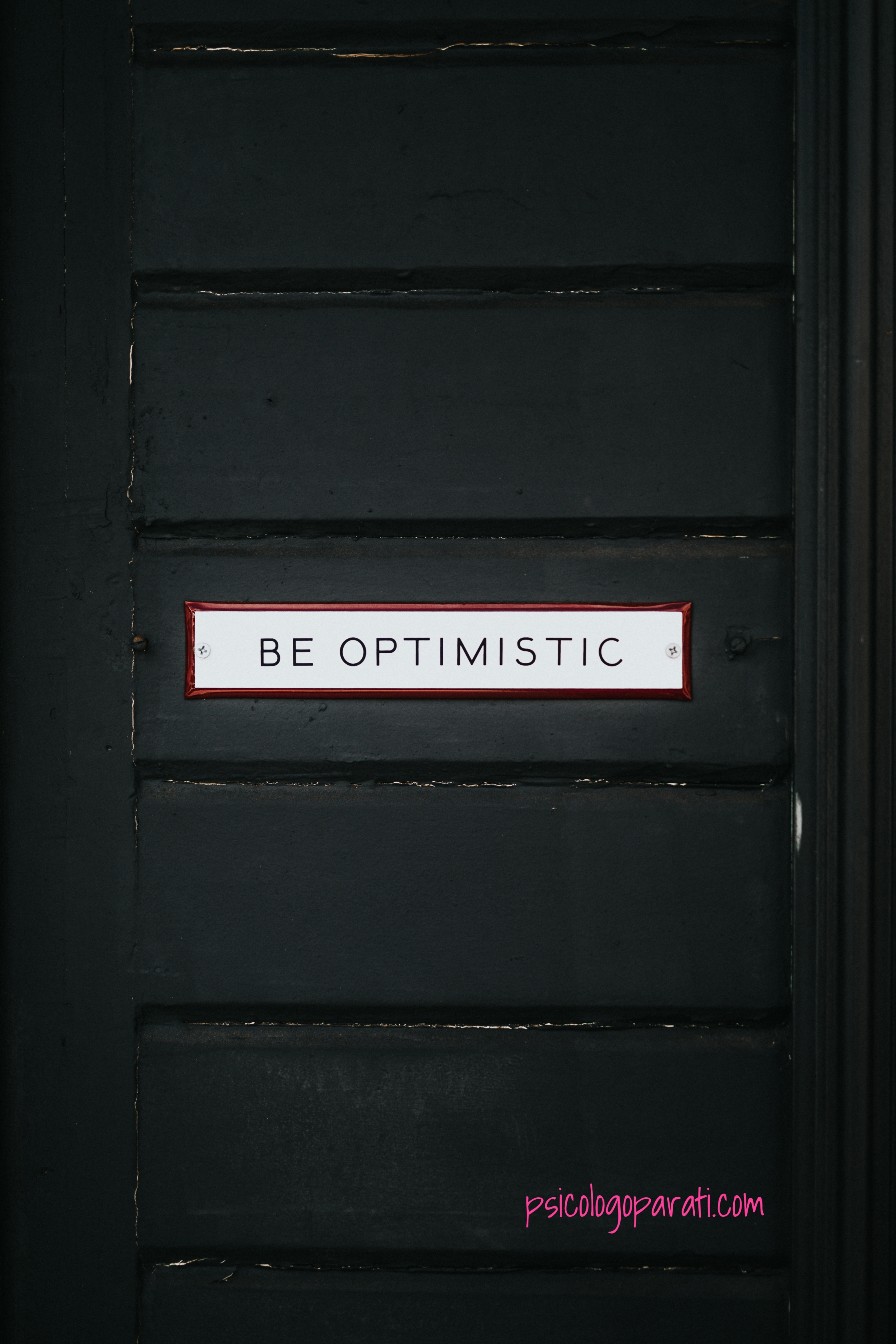 puerta negra con una frase de be optimistic para que se recalque el por qué hay que ser optimista cada día